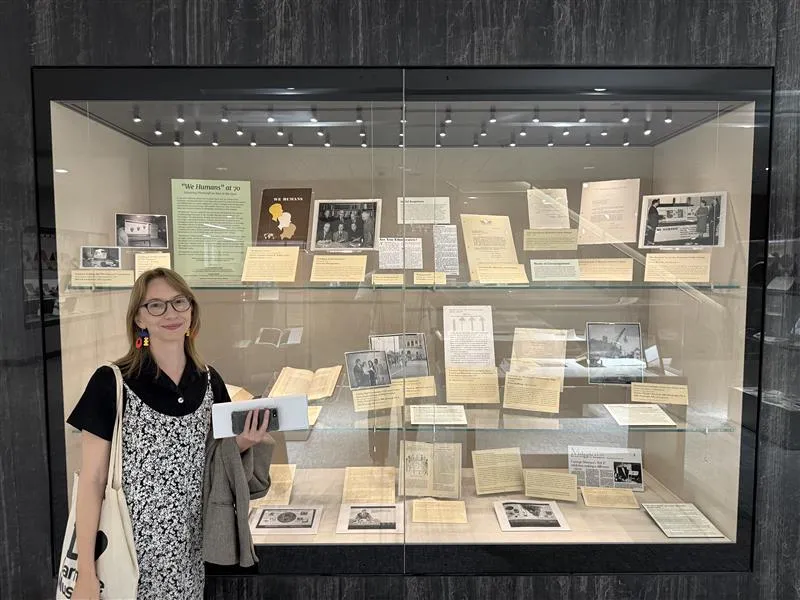 Curator Deirdre Madeleine Smith in front of the We Humans exhibit, 2025